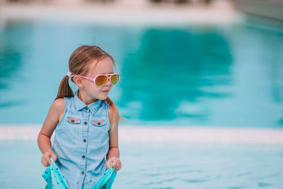 Full length of woman standing by swimming pool