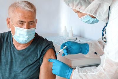 Doctor vaccinating senior man in clinic. elderly people vaccination covid19 coronavirus vaccine