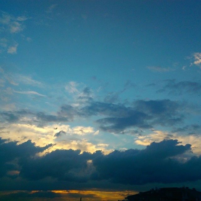 sky, cloud - sky, scenics, beauty in nature, low angle view, tranquility, tranquil scene, sunset, nature, blue, cloudscape, silhouette, cloud, flying, idyllic, airplane, cloudy, outdoors, sky only, no people