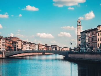 Bridge over river against buildings in city