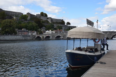 View of boats in river against cloudy sky