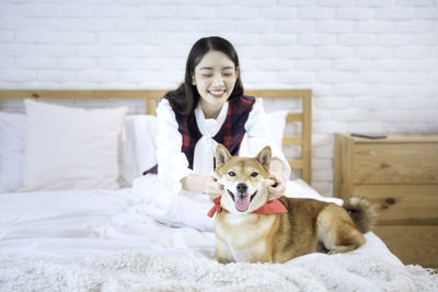 Pet lover concept. an asian girl is learning and parody the smile of her shiba inu dog. 