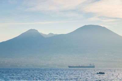 Scenic view of sea and mountains against sky