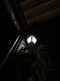 Low angle view of man holding illuminated window at night