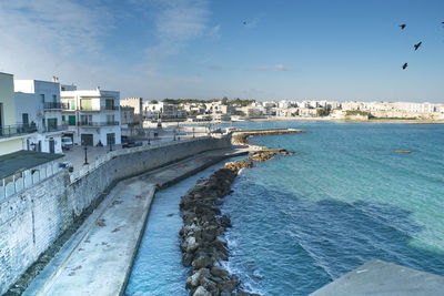 View of city by sea against sky