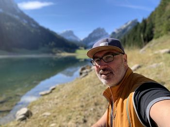 Portrait of young man standing by lake