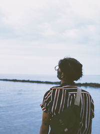 Woman looking at sea against sky