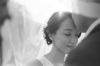 Close-up of bridegroom kissing bride on forehead