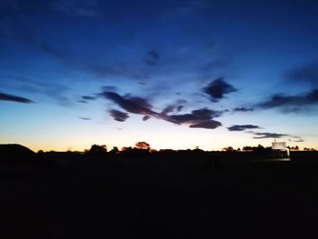 Silhouette landscape against dramatic sky during sunset