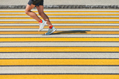 Man running crosswalk copy space. athletic man jogging in sportswear on city road. sprinting outdoor