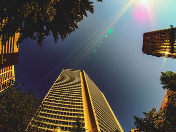 Low angle view of skyscraper against sky during sunset