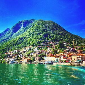 Scenic view of sea and mountains against clear blue sky