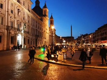 People in illuminated city at night