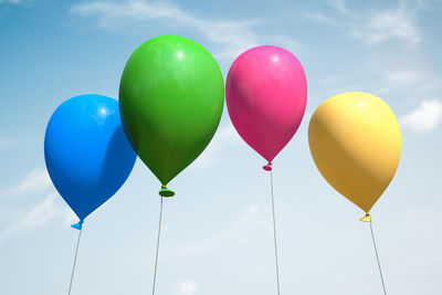 Low angle view of balloons against sky