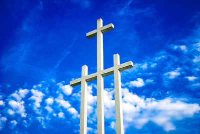 Low angle view of cross against blue sky