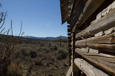 Stack of logs on landscape against mountains