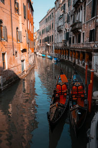 Boats in canal amidst buildings in city