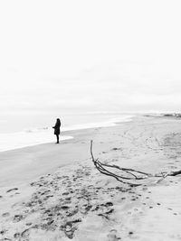 Man on beach against sky during winter