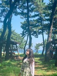 Young woman standing on tree trunk