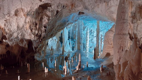 Rear view of people walking in cave