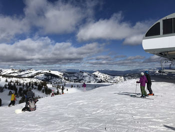 People on snow covered mountain against sky