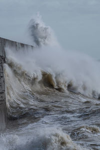 Waves crashing against a sea defence harbour wall at newhaven in east sussex