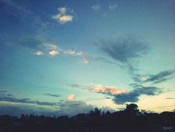 Low angle view of silhouette trees against sky