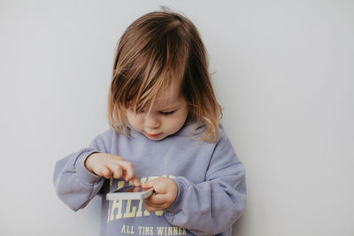 Portrait of girl holding gift against white background