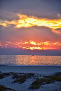 Scenic view of sea against dramatic sky during sunset