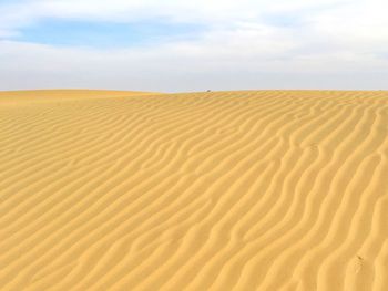 Scenic view of sand dunes against sky