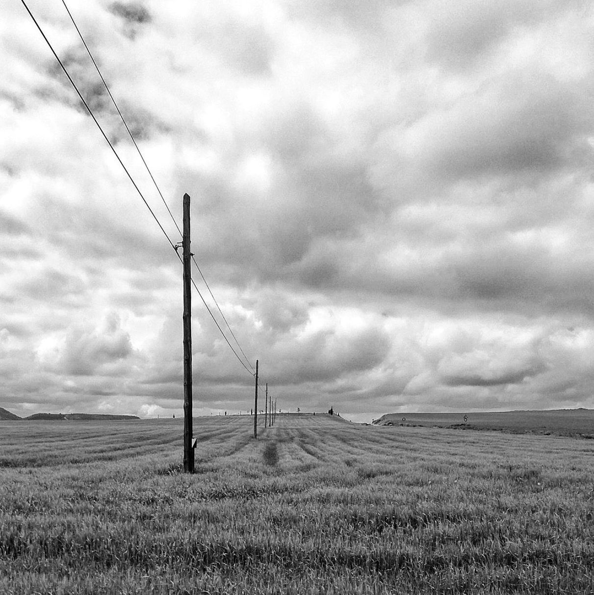sky, cloudy, cloud - sky, field, landscape, fuel and power generation, electricity pylon, grass, tranquil scene, tranquility, cloud, overcast, weather, nature, connection, rural scene, scenics, wind turbine, electricity, alternative energy