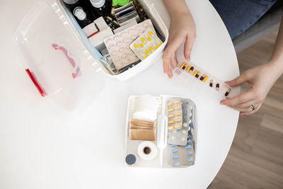 Cropped hands of woman using mobile phone on table