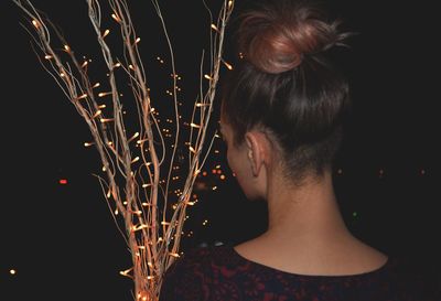 Close-up of woman with illuminated lights at night