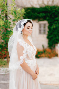 Young woman in bridal clothing standing outdoors