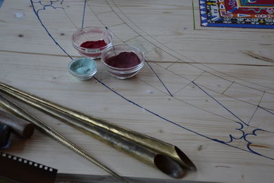 High angle view of powder paint in bowls on drawing