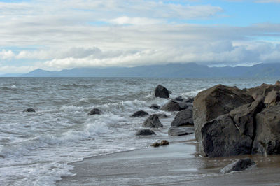 Rocks on beach against sky