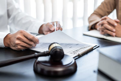 Midsection of lawyer working at desk in office