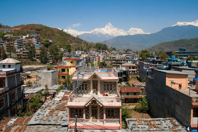 Houses by mountains against sky