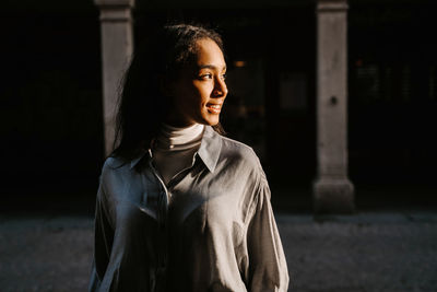 Portrait of young woman looking away outdoors