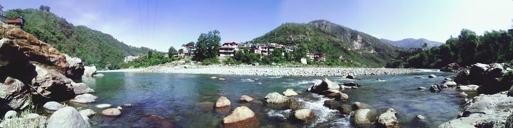 Panoramic view of river and mountains against clear sky