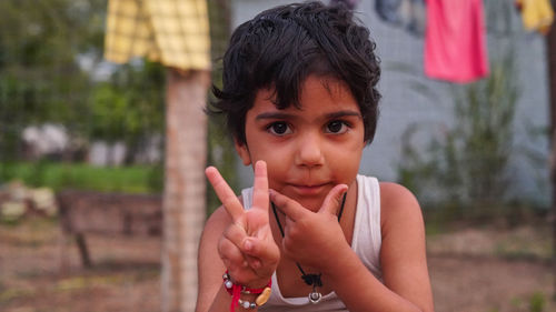 Smart kid making v with fingers. portrait of smiling kid showing victory sign with fingers of hand.
