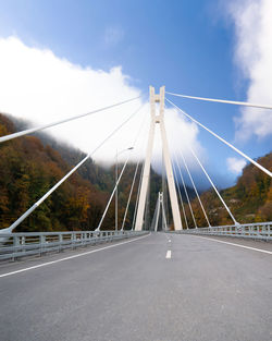 Bridge over road in city against sky