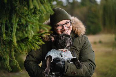 Portrait of mature man with french bulldog dog in forest