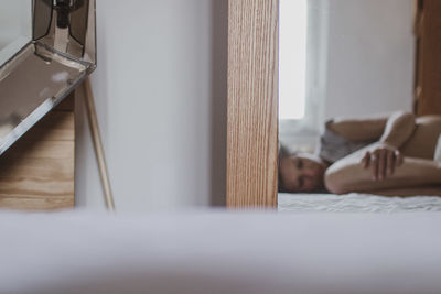 Portrait of woman lying on bed at home