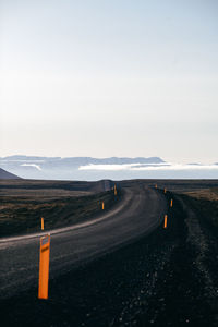 Road leading towards mountain against sky