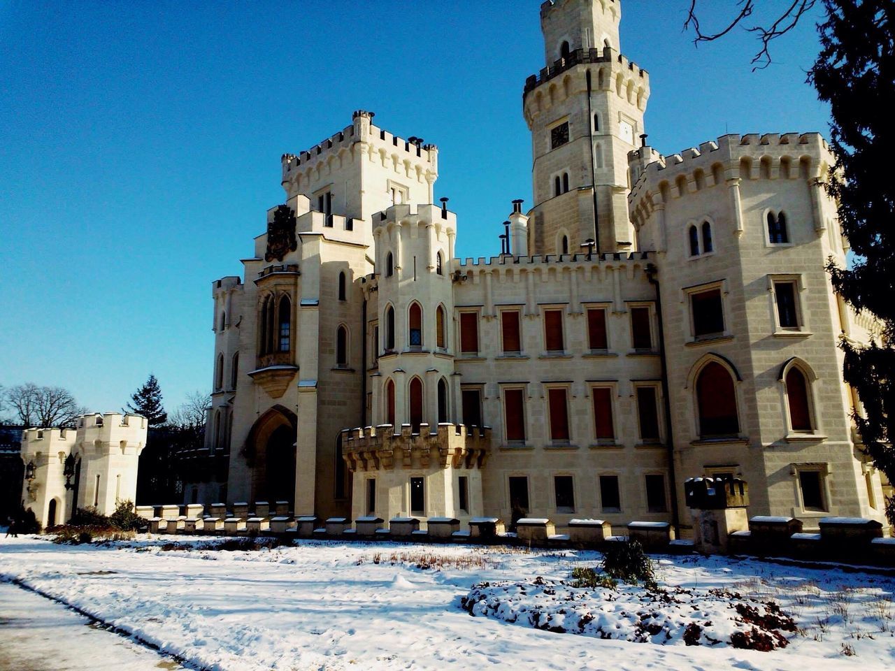 architecture, building exterior, built structure, clear sky, blue, snow, history, winter, low angle view, sunlight, cold temperature, arch, facade, old, day, shadow, place of worship, travel destinations, outdoors, white color