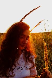 Portrait of woman on field against sky during sunset