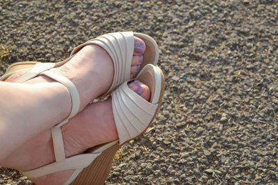 Low section of woman wearing sandals outdoors