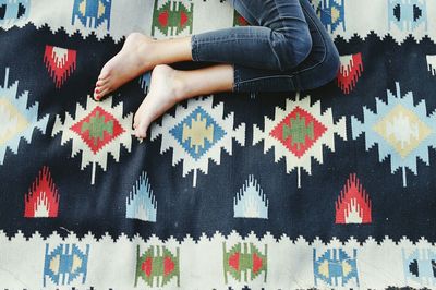 Low section of woman lying on carpet