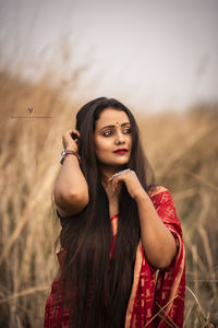 Portrait of young woman standing on field